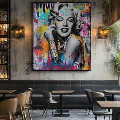 Ručno oslikana premium slika na platnu sa zlatnim akcentima s motivom marilyn monroe s grafitima obješena u modernom stilskom interijeru iznad drvene konzole s vazom i svijećom, Papilora.