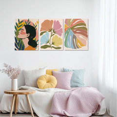 Slika na platnu s motivom žena, cvijeće i lišće u boji obješena u modernom stilskom interijeru iznad drvene konzole s vazom i svijećom, Papilora.