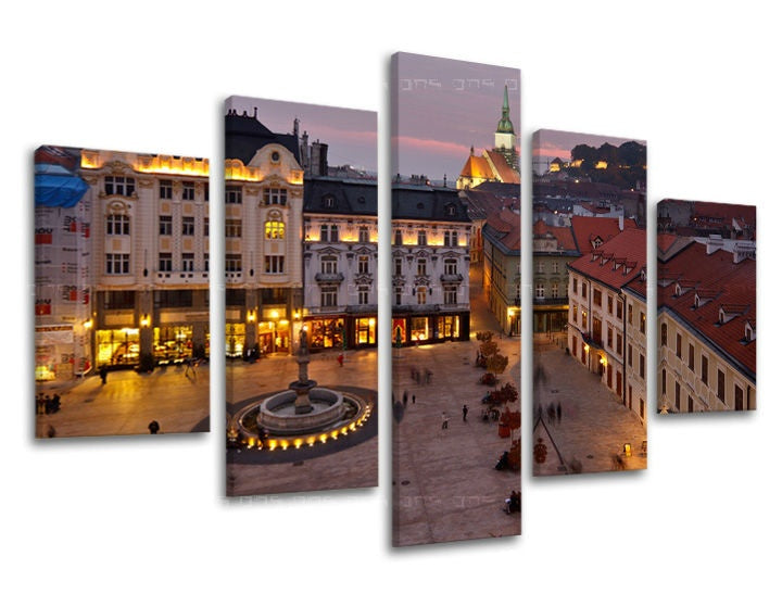 Slika na platnu s motivom gradski trg s fontanom i zgradama noću – 3D prikaz platna s vidljivim drvenim okvirom, Papilora.