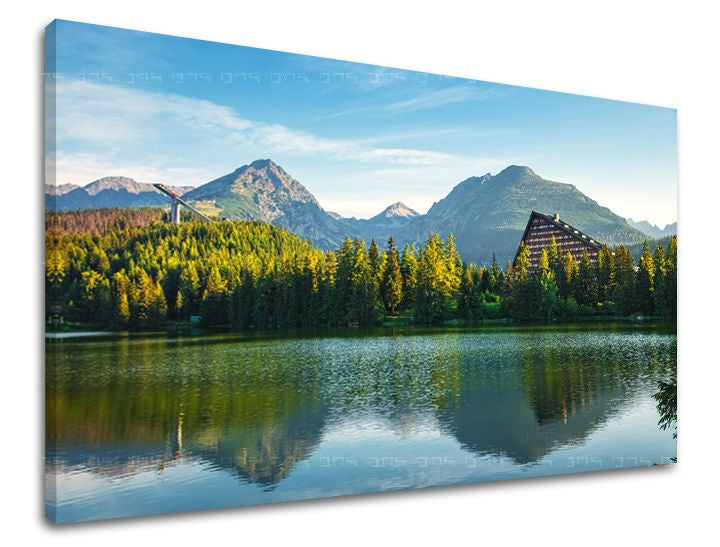 Slika na platnu s motivom planinsko jezero s borovima i zgradama – 3D prikaz platna s vidljivim drvenim okvirom, Papilora.